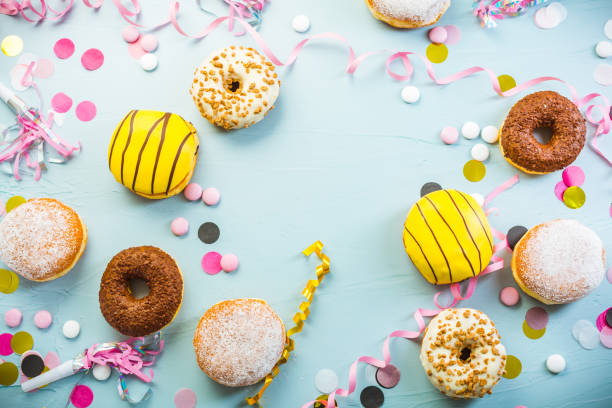 German Krapfen or donuts with streamers and confetti. Traditional Berliner for carnival and party.. Colorful carnival or birthday image