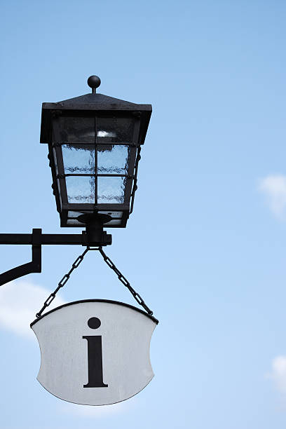 istock old-fashioned street light and information symbol against blue sky, Germany 145988351