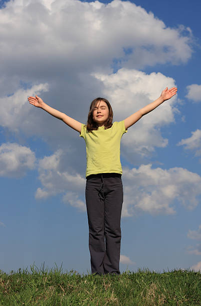 istock Girl holding hands up against blue sky 145988449