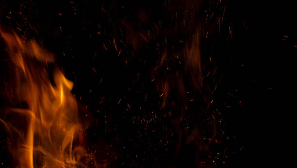 istock Sparks and fire on a black background. Abstract blurred bonfire with sparks and flames. 1459884953