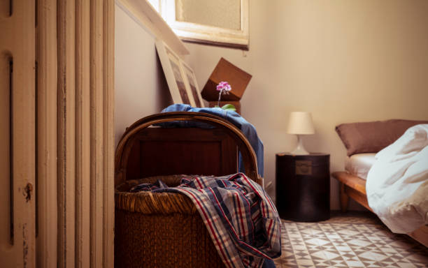 istock Unwashed clothes in basket and bed in bedroom 1459888501