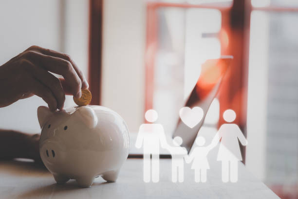 businessman putting coin on the piggybank and icon family on table, donation, saving, charity, family finance plan concept, fundraising, superannuation, investment, stock photo