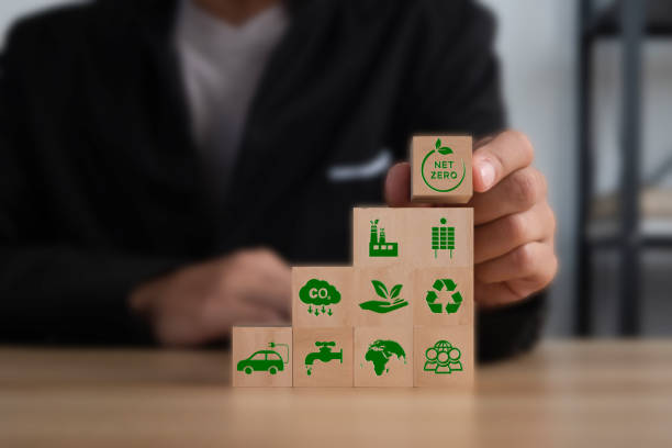 istock Businessman puting wooden cubes with green net zero icon on table. Net zero and carbon neutral concept. Net zero greenhouse gas emissions target. Climate neutral long term strategy. 1459889945