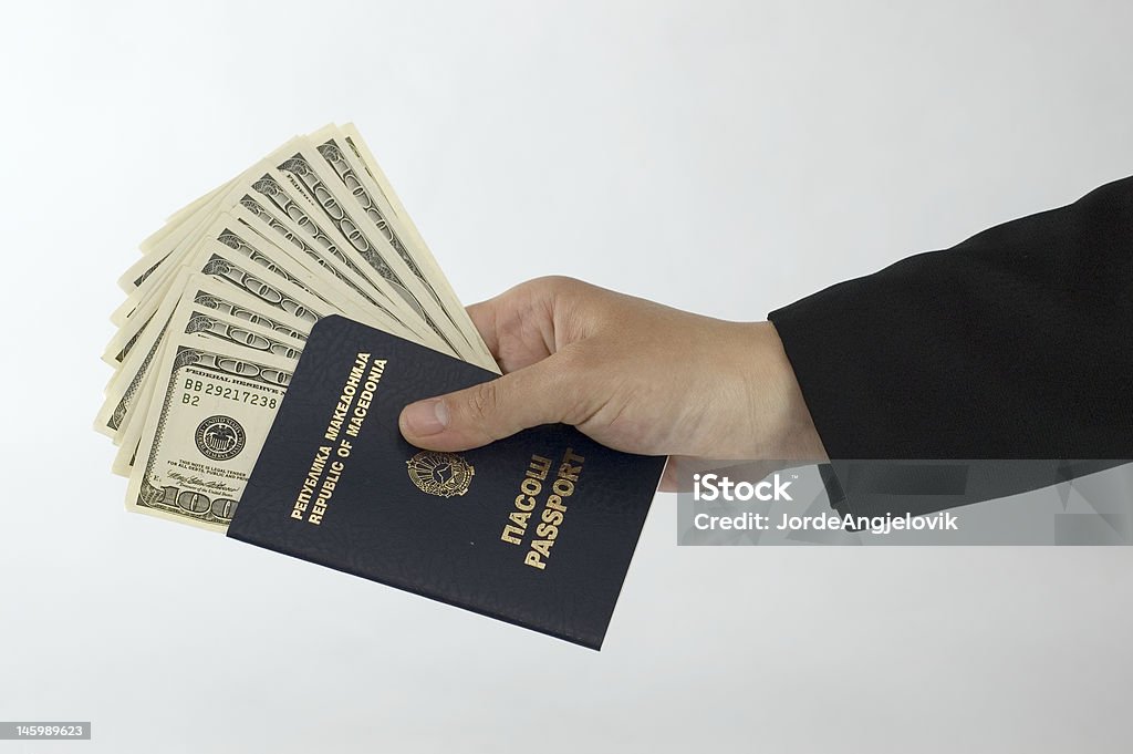 Main tenant dollars avec un passeport - Photo de Affaires libre de droits