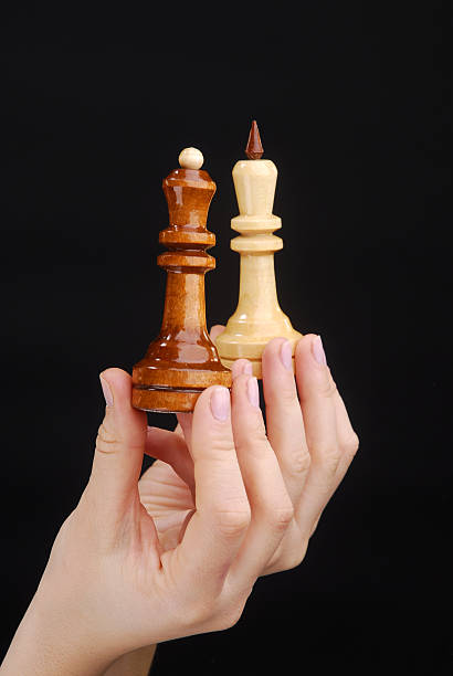 Two hands with chesspieces king and queen stock photo