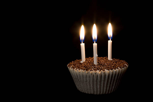 Cupcake with candles in the dark stock photo