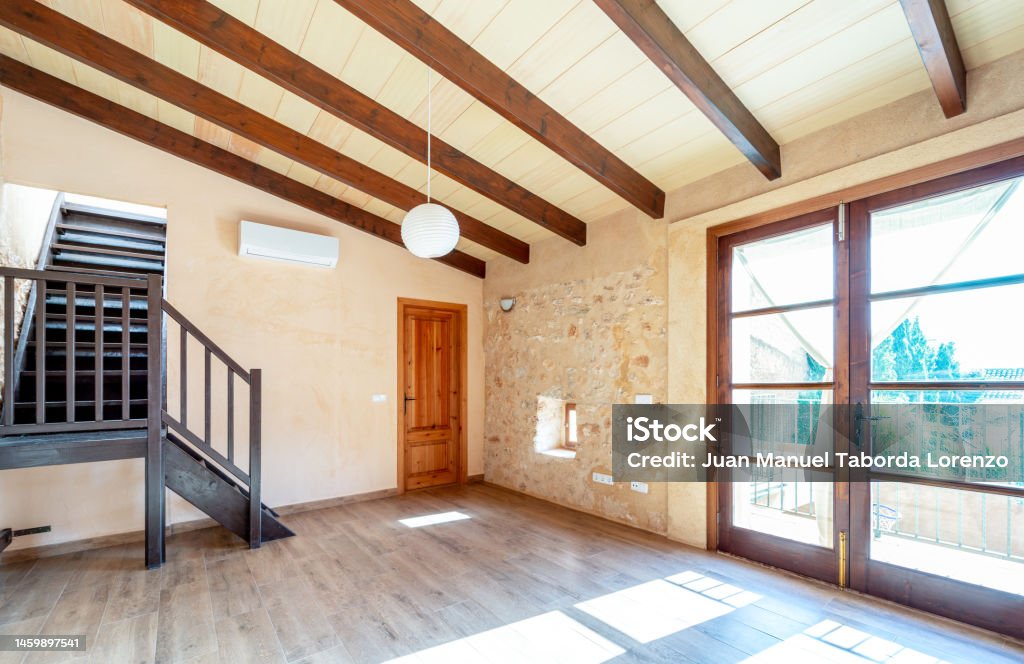 Open plan empty master bedroom with parquet floors, wooden beams, balcony and air conditioning in rustic style Air Conditioner Stock Photo