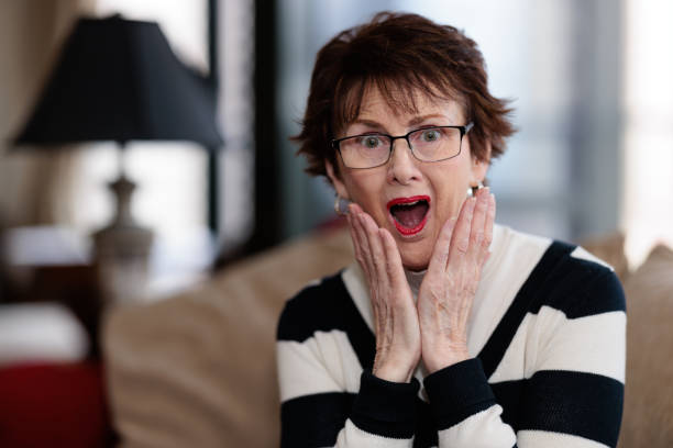 istock Senior woman indoors getting a surprise 1459898374