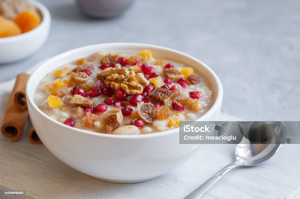 Traditional Turkish delicious mixed dessert, ashura (asure) with pomegranate seeds, walnut, apricot, Noah’s pudding Ashura - Muharram Stock Photo