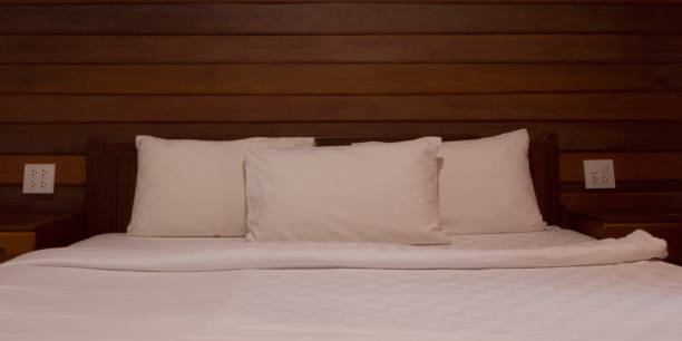 istock white pillows and blanket in wooden bed 1459899618