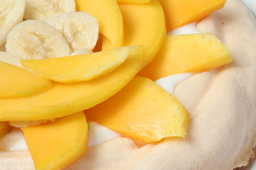 close up image of mango and banana pavlova