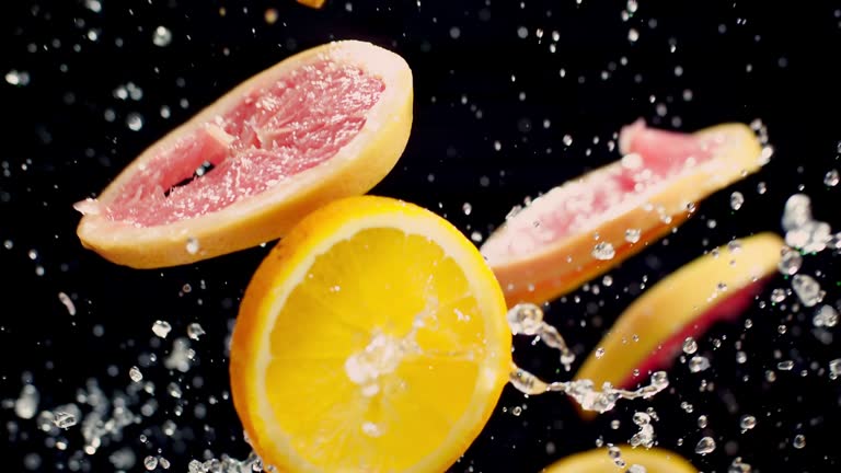 Grapefruit, Orange and Water Rotation on Black Background - Super Slow Motion