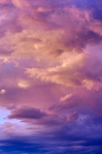 Sunrise from the edge of foggy mountain after raining in the night. The colors of sky and mountains change to purple and blue.