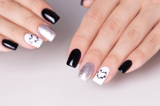 istock Female hands with black manicure nails, hearts design 1459913642