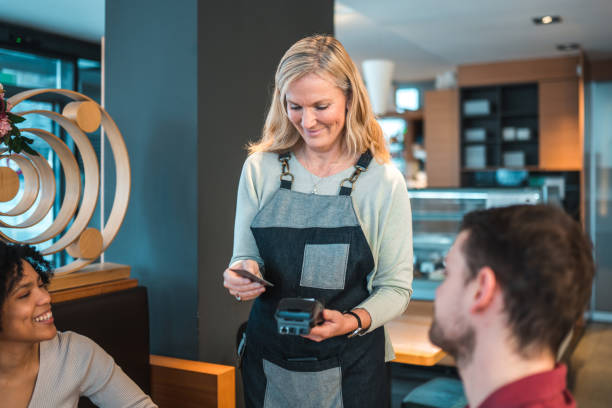 istock Mature Caucasian Waitress Holding A POS Terminal In A Cafe 1459914035