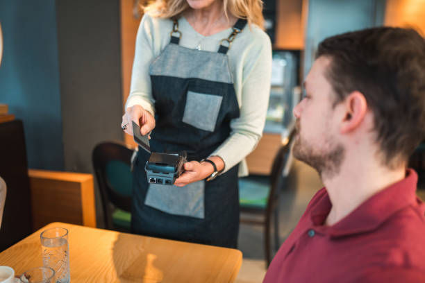 istock Caucasian Male Using A Credit Card In A Cafe 1459914151