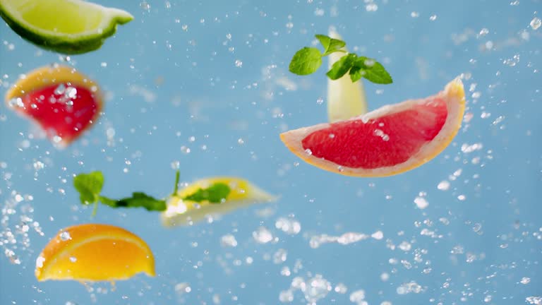 Grapefruit, Lime, Orange and Water Rotation on Blue Background - Super Slow Motion