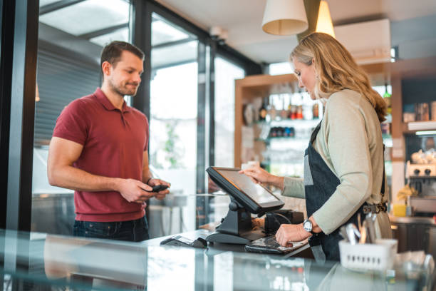 istock Caucasian Male Paying In A Cafe Using Smartphone 1459915130