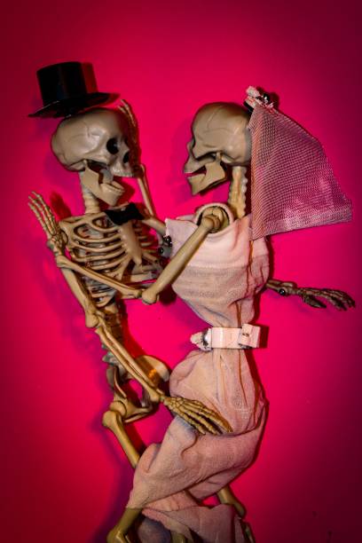istock Happily married skeleton couple dancing on their wedding night on the pink background 1459915191