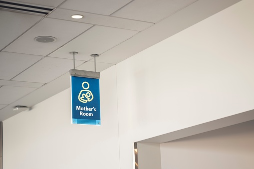 A low angle shot of a blue mother's room sign inside an airport