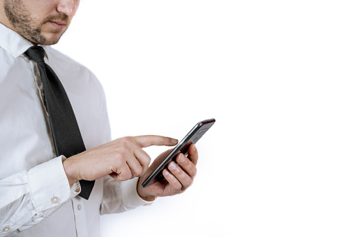 A young businessman in formal wear using his smartphone