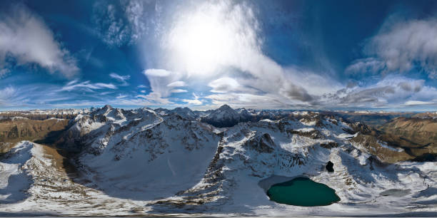 panorama gór ośnieżonych pasm z turkusowym jeziorem, słoneczny dzień z chmurami - sunny day mountain mountain range winter zdjęcia i obrazy z banku zdjęć