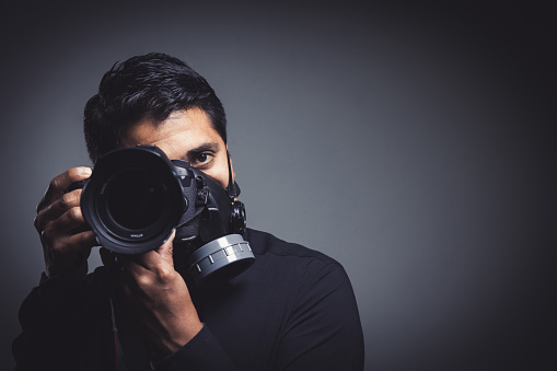 A closeup shot of a male taking a photo in a protective gas mask