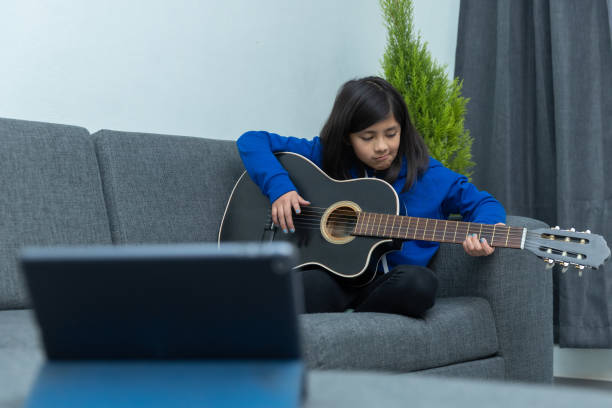 istock Mexican girl learning to play the guitar 1459919346