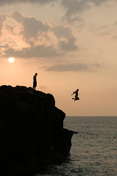 istock Silhouette of cliff jumpers at sunset 145992013