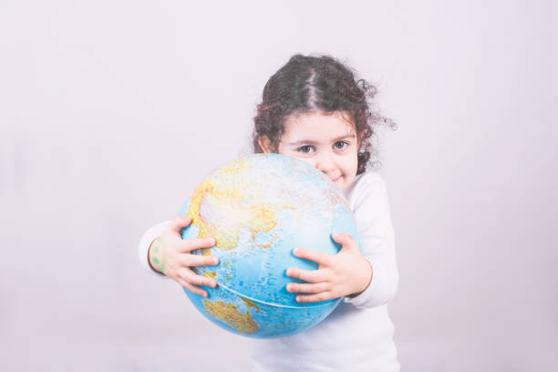istock Closeup portrait curious child holding an earth globe map in his hand 1459920447