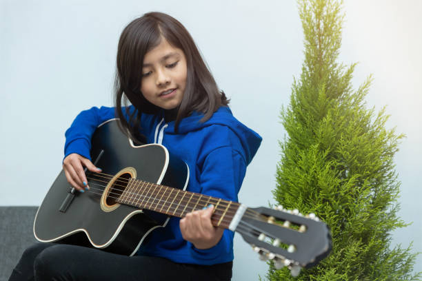 istock Mexican girl learning to play the guitar 1459920536
