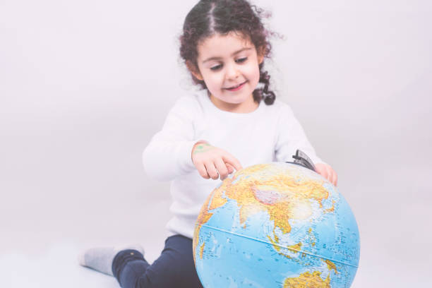 istock Closeup portrait curious child holding an earth globe map in his hand 1459920806