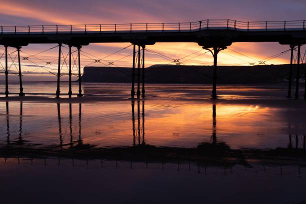 istock Scenic sunset cloudscape reflecting on the beach behind the Saltburn Pier 1459921270