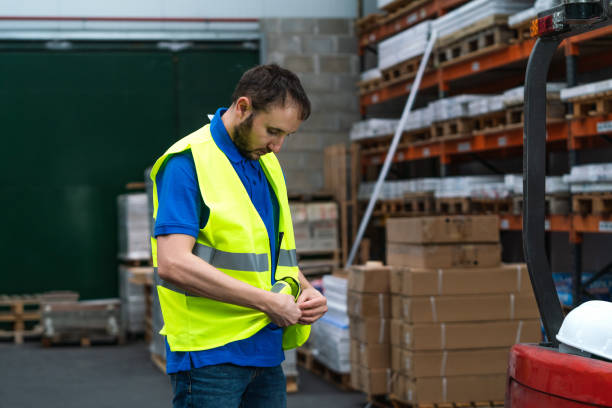istock Caucasian male worker in a warehouse buttoning his yellow uniform 1459922106