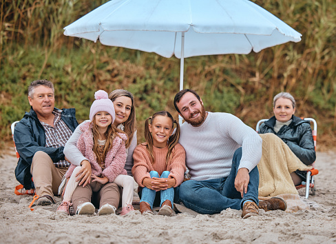 Beach, sand and portrait of happy family relax on on ocean seashore for peace, freedom and quality time on travel vacation. Love, bond and big family of grandparents, parents and children on holiday