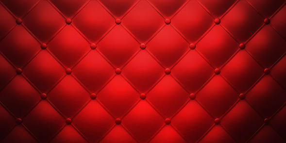 Red leather background, classic retro Chesterfield style soft tufted furniture upholstery with deep diamond pattern and buttons, close up