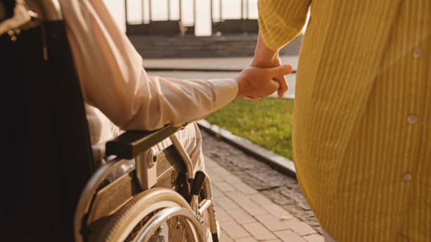 istock Man with reduced mobility holding wife's hand, support in relationship, love 1459922936