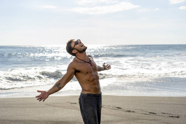 istock Excited shirtless man on the beach washed by ocean waves 1459924279