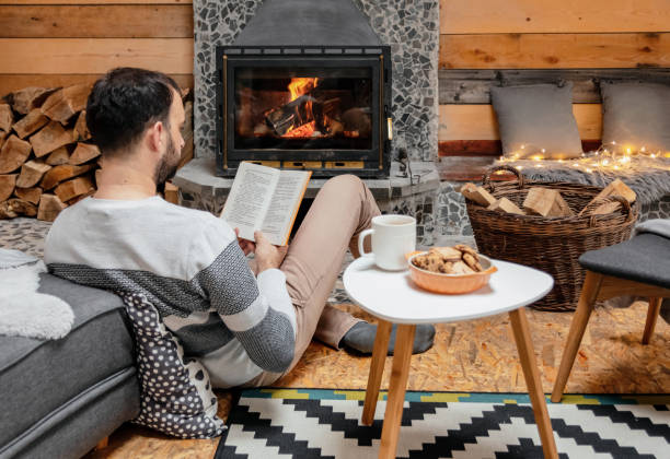 istock Caucasian man reading a book near the fireplace 1459924905