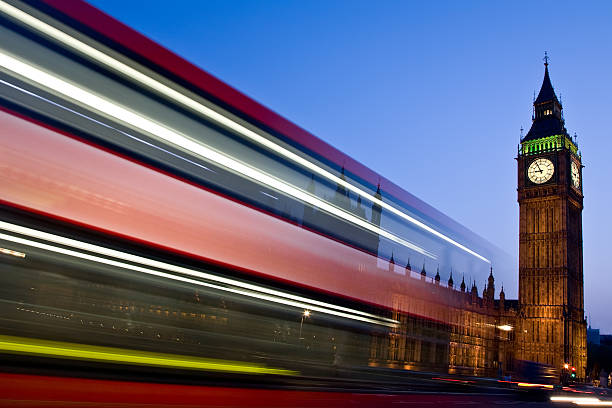 London bus blurs past Big Ben and Houses of Parliament stock photo