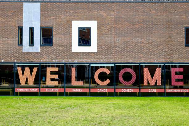 istock Welcome sign in front of a building on green grass. 1459926847
