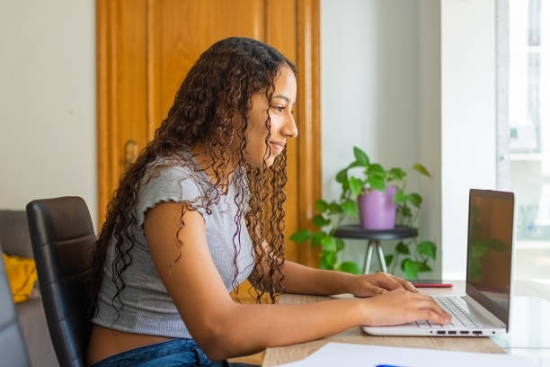istock Girl working on her computer in her room while she's social distancing 1459927076