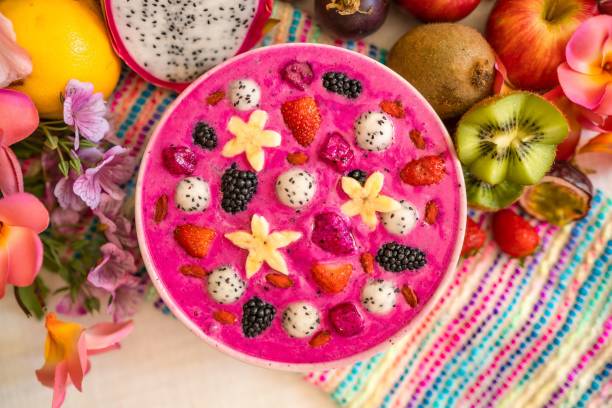 Top view of delicious tropical pink dragon fruit with berry smoothie in a bowl