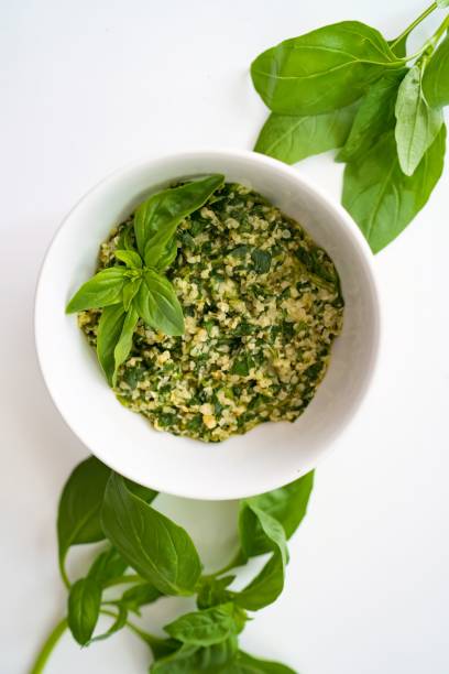 A top view of vegan basil pesto on a white table background