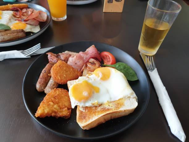 istock Big breakfast with fried eggs, sausages, tomatoes and a cup of lemonade 1459931907