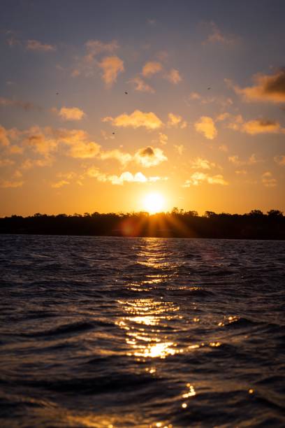 pôr do sol laranja cênico e nuvens bonitas sobre uma paisagem marítima no porto de charleston - charleston harbor - fotografias e filmes do acervo