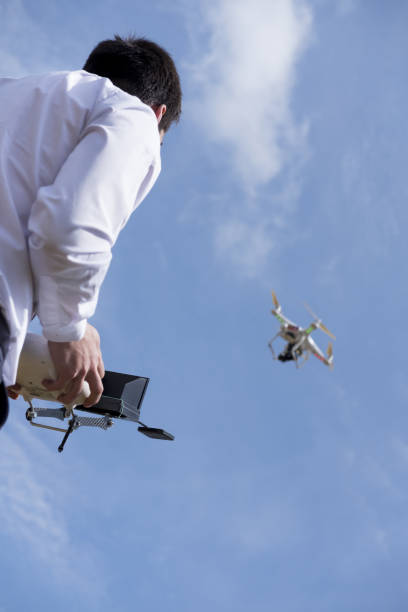 Low angle shot of a male in a flight school uniform piloting during a drone flight practice