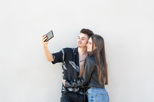 A beautiful shot of a Caucasian couple taking a selfie isolated on a white background