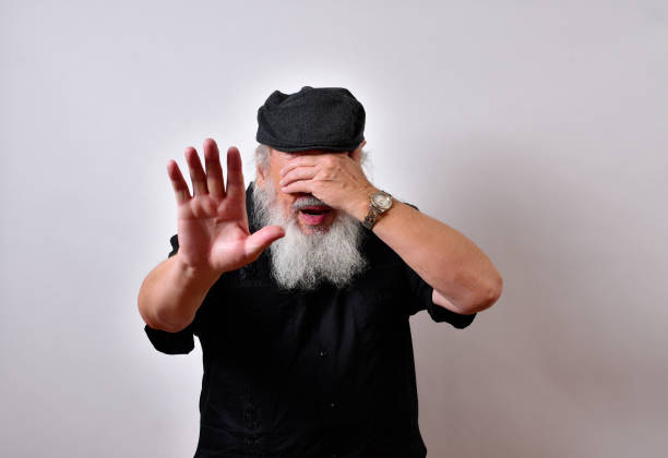 istock American senior man has eyes covered and hand blocking a horror 1459934114