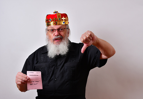 A mature jerk wearing a crown and black guayabera shirt fires an employee